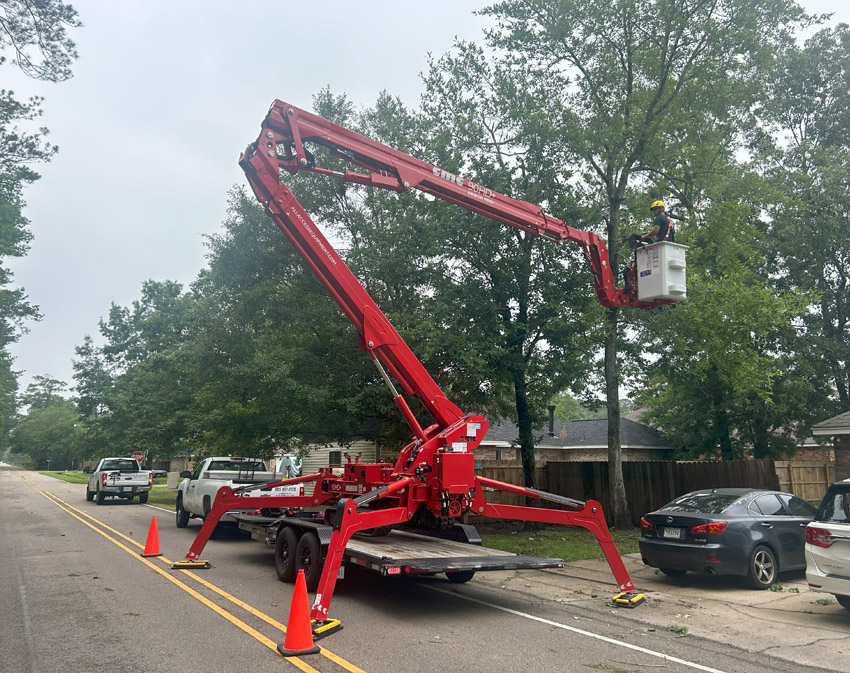 Arborist in Covington, LA operating with a crane to access and safely prune high-risk branches. Crane-assisted techniques are essential for maintaining large trees and mitigating hazards near homes and structures.
